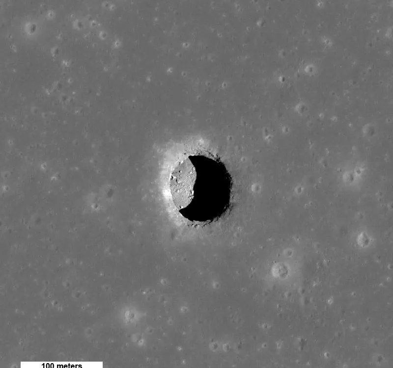 A grey image of a pit on the surface of the moon